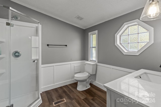 bathroom featuring a wealth of natural light, vanity, toilet, and a shower with shower door