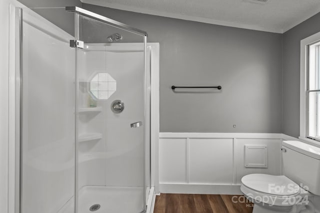 bathroom featuring walk in shower, plenty of natural light, hardwood / wood-style floors, and toilet