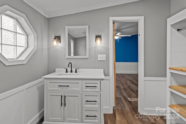 bathroom with a textured ceiling, wood-type flooring, vaulted ceiling, and vanity