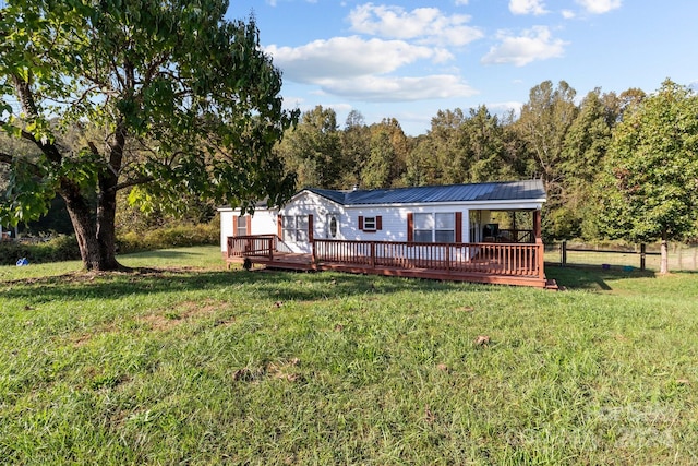 rear view of house with a yard and a wooden deck