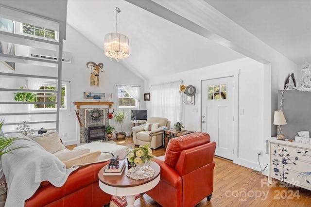 living room featuring a notable chandelier, light hardwood / wood-style flooring, a wood stove, and high vaulted ceiling