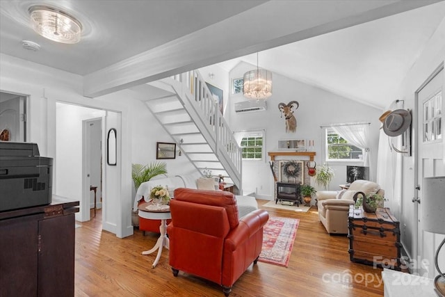 living room with a notable chandelier, light hardwood / wood-style floors, and high vaulted ceiling