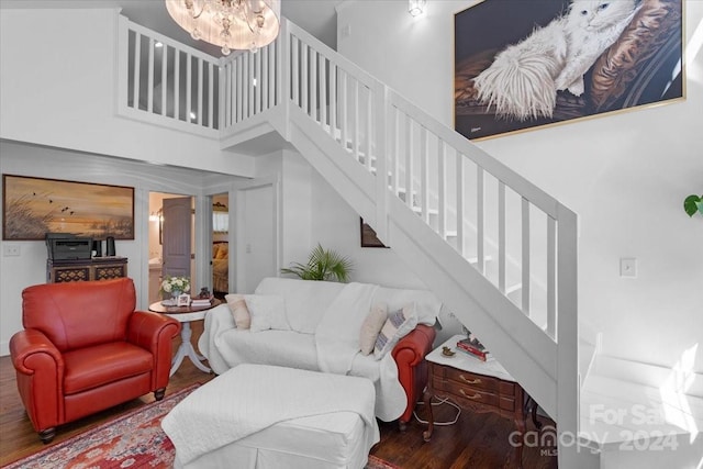 living room featuring hardwood / wood-style flooring, a chandelier, and a high ceiling