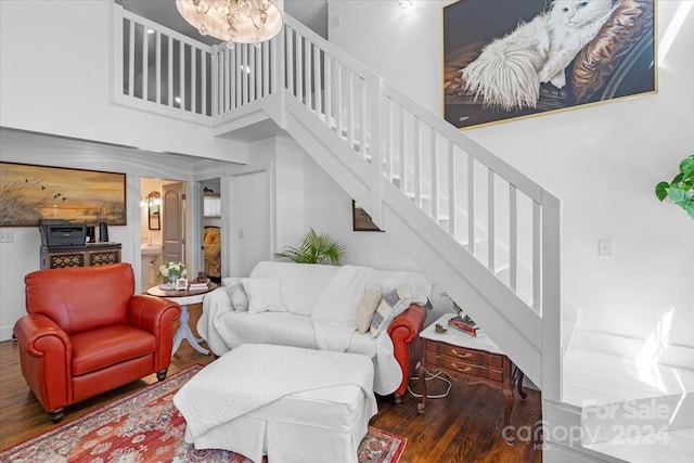 living room featuring a towering ceiling and dark hardwood / wood-style floors