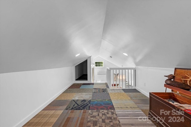 bonus room featuring dark colored carpet and vaulted ceiling