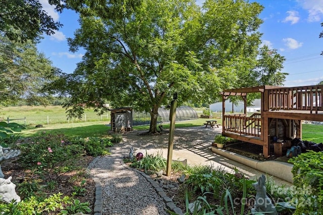 view of home's community with a wooden deck, a yard, and a patio