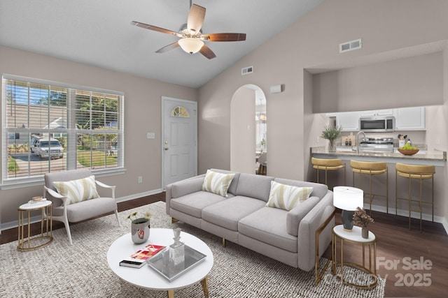 living room featuring hardwood / wood-style flooring, vaulted ceiling, and ceiling fan