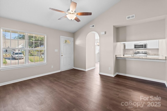 unfurnished living room featuring ceiling fan, dark hardwood / wood-style floors, and lofted ceiling