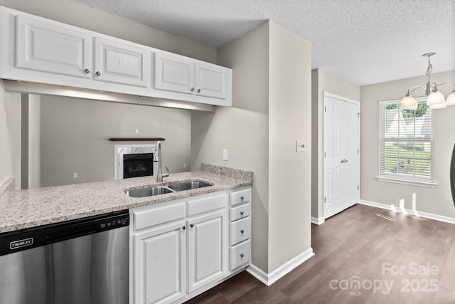 kitchen featuring pendant lighting, white cabinets, sink, stainless steel dishwasher, and a notable chandelier