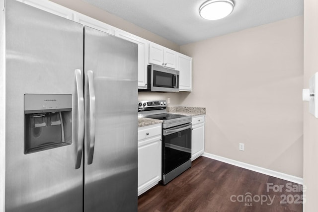 kitchen featuring white cabinets, dark hardwood / wood-style floors, a textured ceiling, light stone counters, and stainless steel appliances