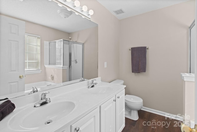 full bathroom with hardwood / wood-style floors, vanity, plus walk in shower, toilet, and a textured ceiling