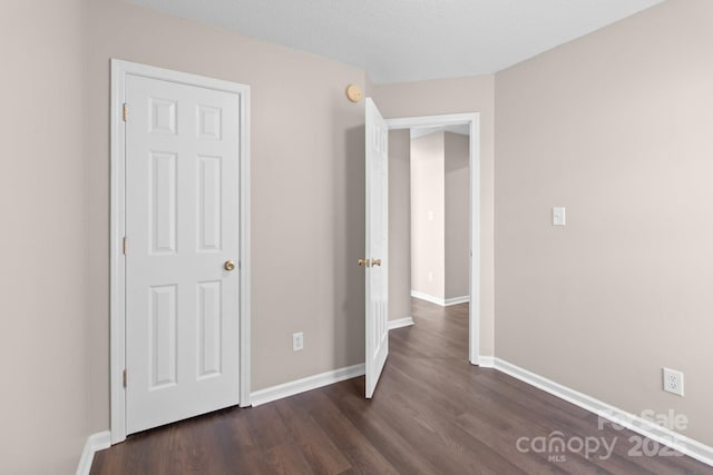 unfurnished bedroom with dark hardwood / wood-style floors