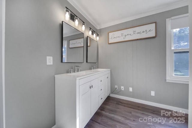 bathroom featuring hardwood / wood-style floors, plenty of natural light, crown molding, and vanity