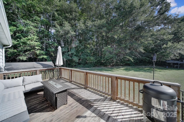 wooden terrace featuring a lawn, a grill, and an outdoor hangout area