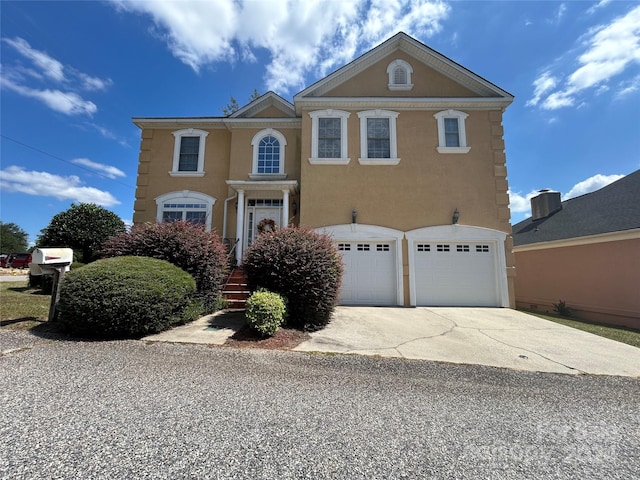 view of front of home with stucco siding, concrete driveway, and a garage