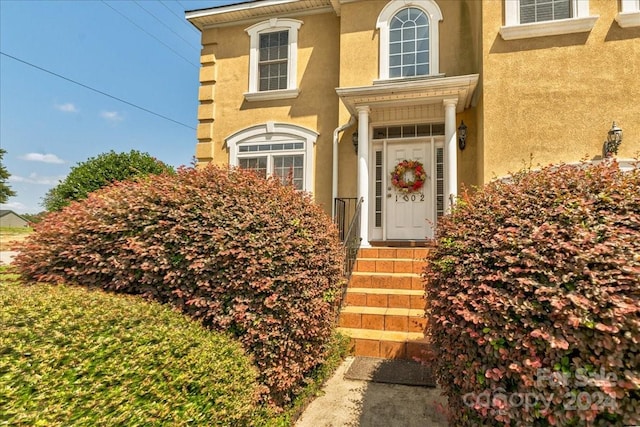 property entrance with stucco siding