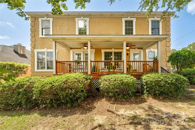 back of property with stucco siding, a porch, and a ceiling fan