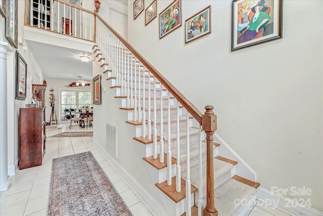 stairs with ceiling fan and tile patterned flooring