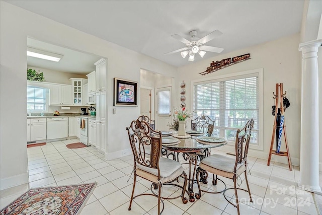 dining room with light tile patterned floors, baseboards, a ceiling fan, and ornate columns