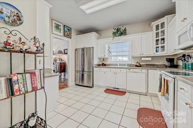 kitchen featuring light tile patterned floors, white appliances, and white cabinetry