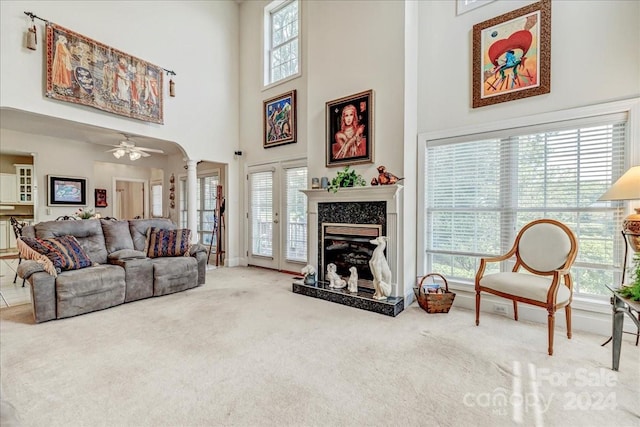 living room featuring ceiling fan, a wealth of natural light, a high end fireplace, and carpet floors