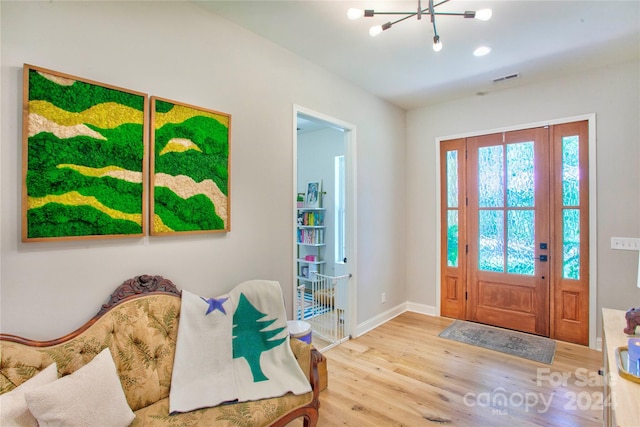 foyer with light hardwood / wood-style flooring and a chandelier