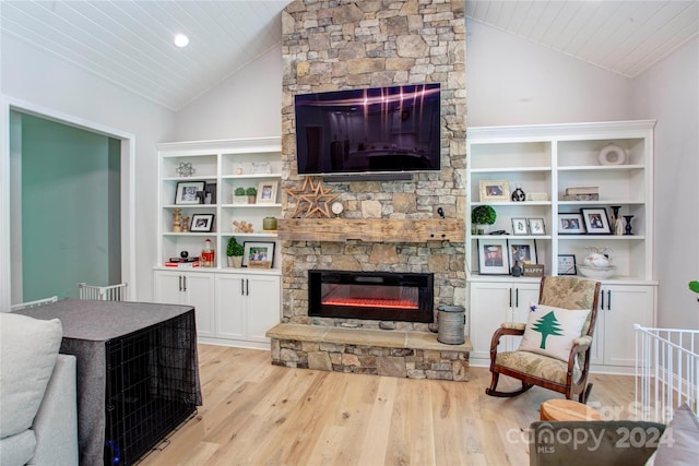 living room with light hardwood / wood-style floors, crown molding, a stone fireplace, and lofted ceiling