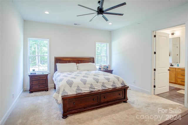 carpeted bedroom featuring ceiling fan and ensuite bath