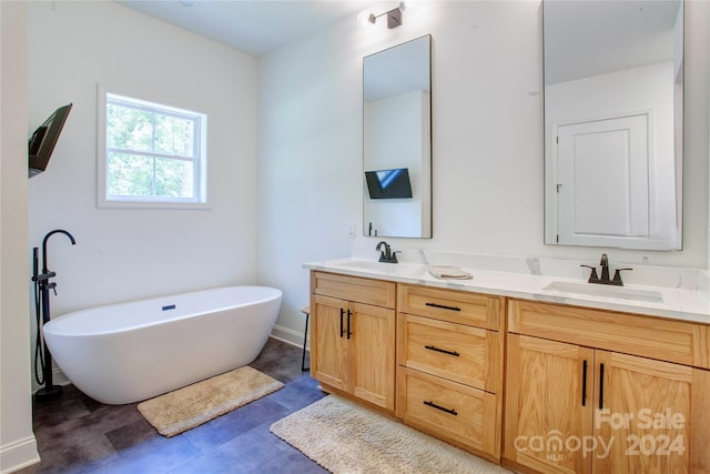 bathroom featuring a bathtub, vanity, and tile patterned floors