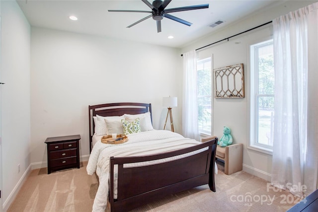 carpeted bedroom with ceiling fan and multiple windows