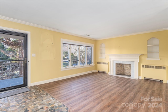 unfurnished living room featuring radiator heating unit, wood-type flooring, built in features, and ornamental molding