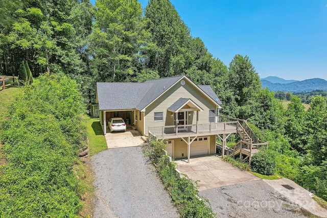 view of front facade with roof with shingles, gravel driveway, a garage, a carport, and stairs