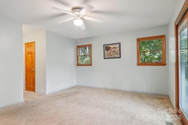 spare room featuring ceiling fan and light colored carpet