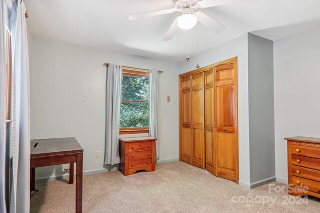 carpeted bedroom featuring ceiling fan and a closet