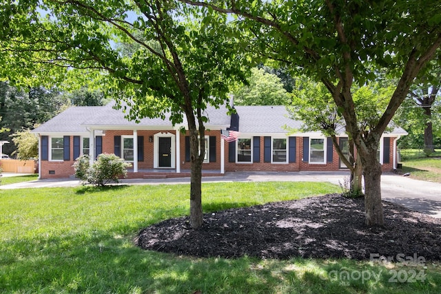 single story home with covered porch, brick siding, a front yard, and roof with shingles