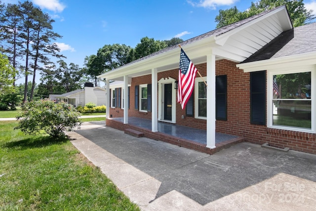 view of side of property featuring brick siding and covered porch