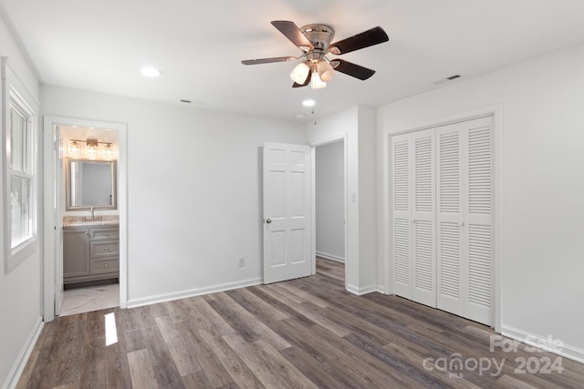 unfurnished bedroom with visible vents, baseboards, wood finished floors, and a closet