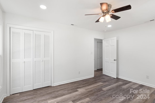 unfurnished bedroom with ceiling fan, a closet, and wood-type flooring