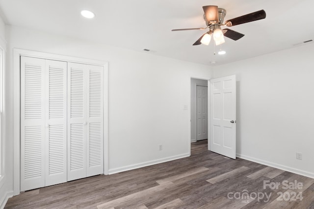 unfurnished bedroom featuring wood finished floors, a closet, baseboards, visible vents, and recessed lighting