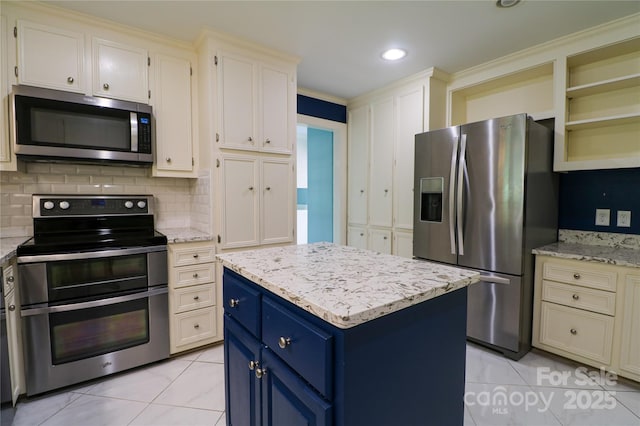 kitchen featuring light stone countertops, a center island, blue cabinets, light tile patterned floors, and appliances with stainless steel finishes