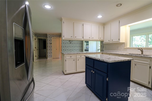 kitchen featuring white cabinetry, sink, a center island, and stainless steel refrigerator with ice dispenser