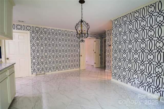 unfurnished dining area featuring a notable chandelier and ornamental molding