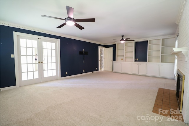 unfurnished living room with a fireplace, french doors, light colored carpet, and built in features