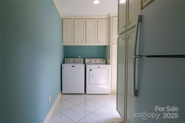 clothes washing area featuring light tile patterned flooring, cabinets, and washing machine and clothes dryer