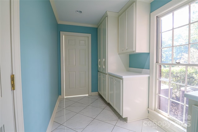 laundry room featuring light tile patterned floors and crown molding