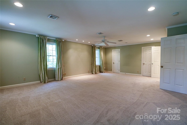 carpeted spare room with ceiling fan and ornamental molding