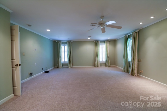 carpeted spare room with ceiling fan and ornamental molding