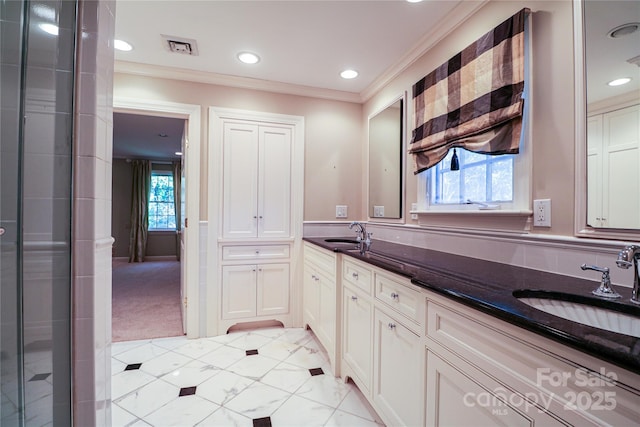 bathroom featuring vanity, a healthy amount of sunlight, ornamental molding, and a shower with door