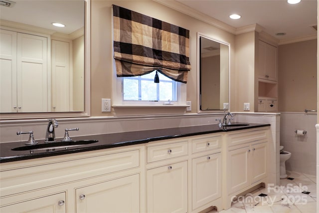 bathroom with tile patterned floors, toilet, vanity, tile walls, and ornamental molding