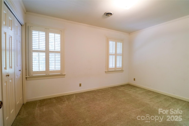 carpeted empty room featuring ornamental molding